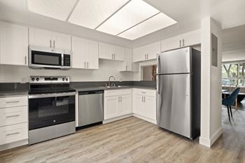 A kitchen with white cabinets and stainless steel appliances.